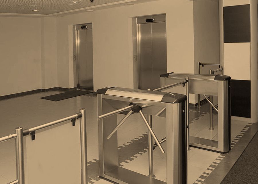 Glass turnstiles and access-control lanes at a building entrance