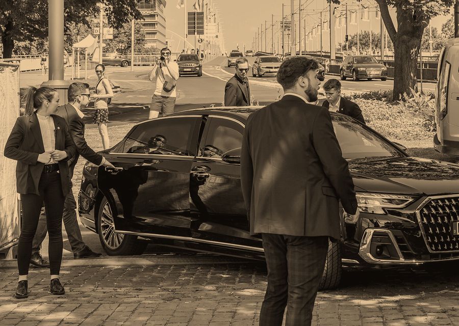 Close-protection officers beside a vehicle on a VIP movement